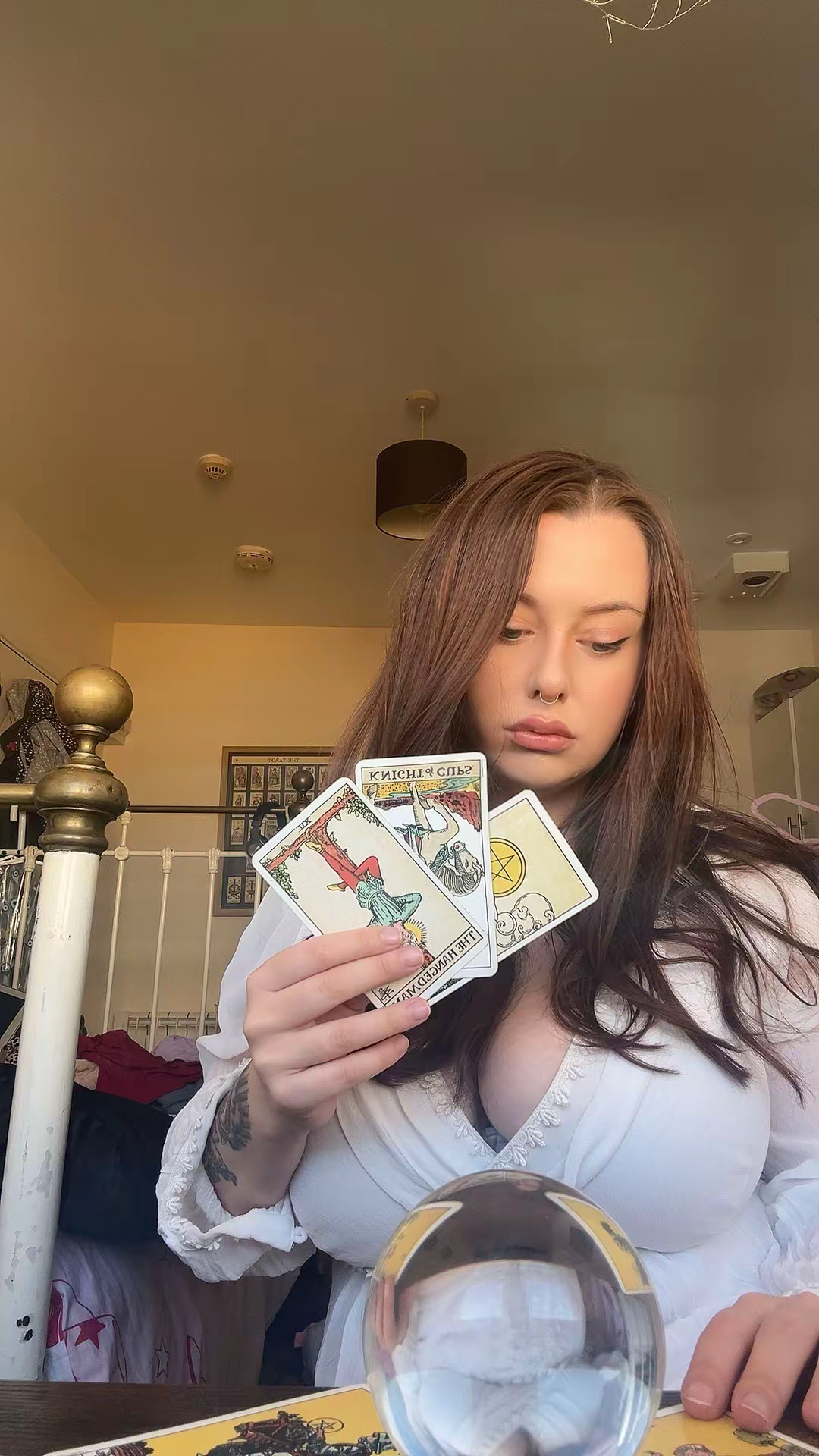 Crystal the Witch holding a spread of tarot cards indoors