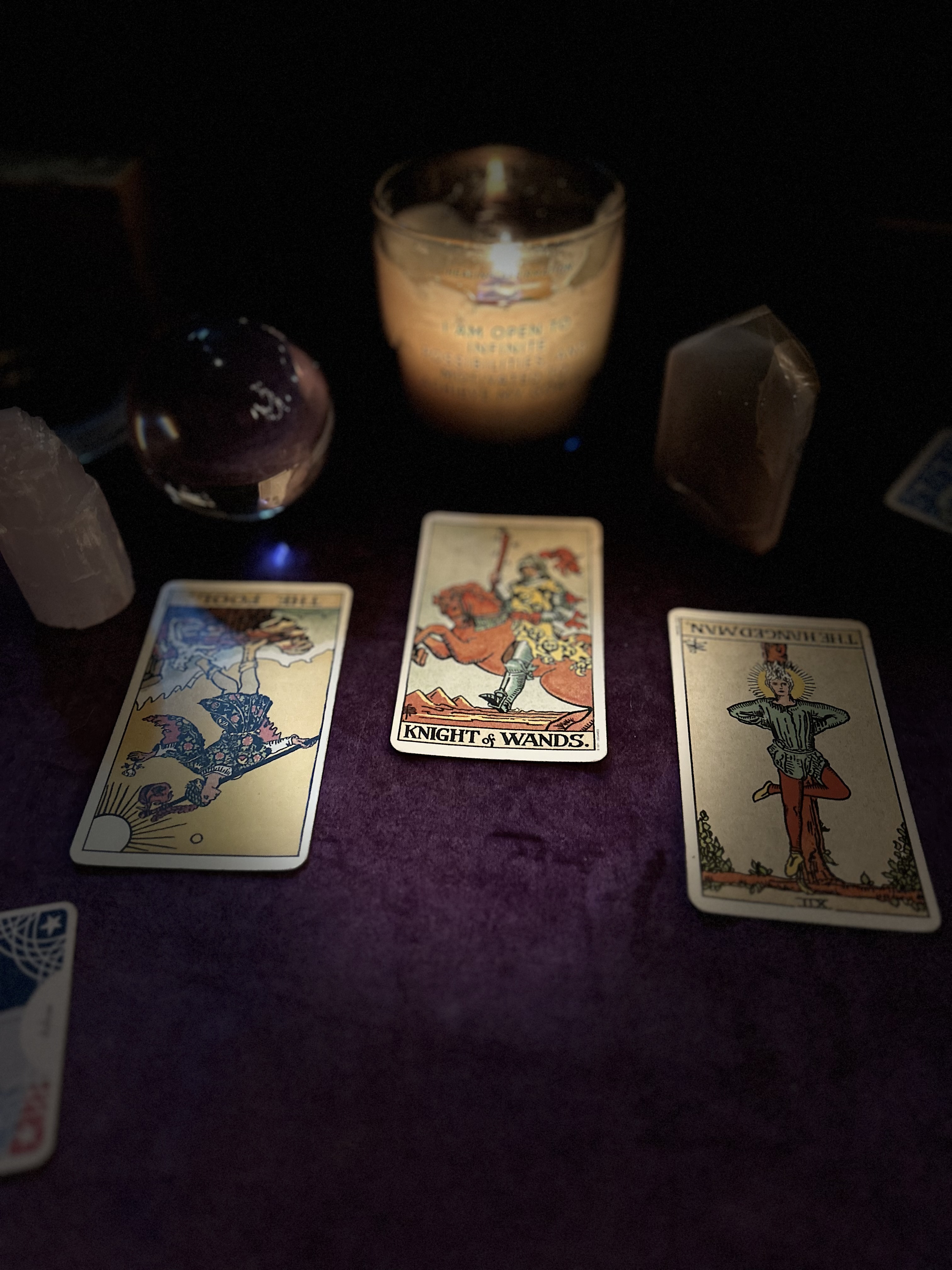 Tarot card reading spread with three cards and crystals